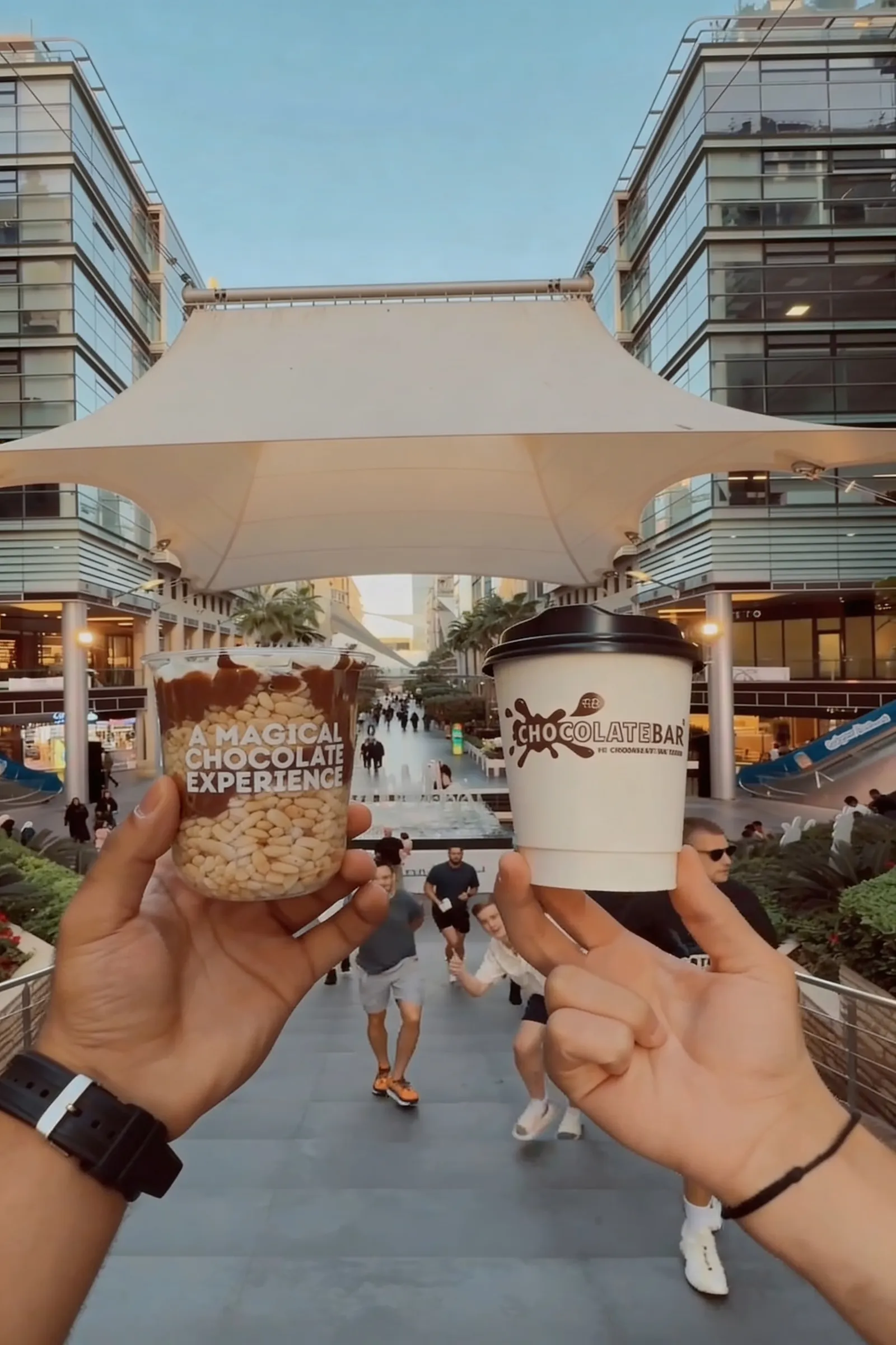 Hands holding ChocolateBar signature cups